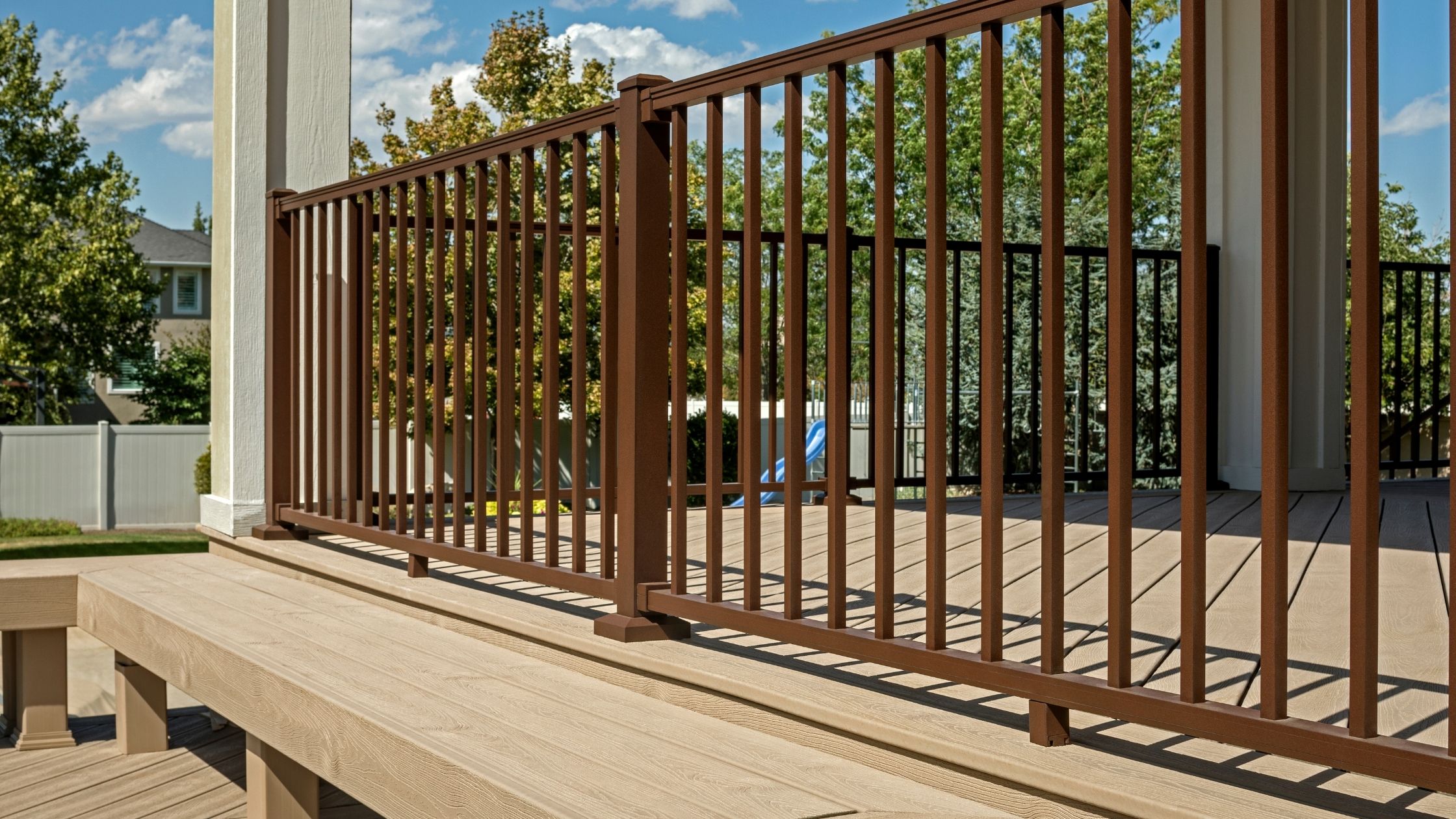 Trex Signature railing system in brown aluminum with rod infill shown on a modern composite deck.