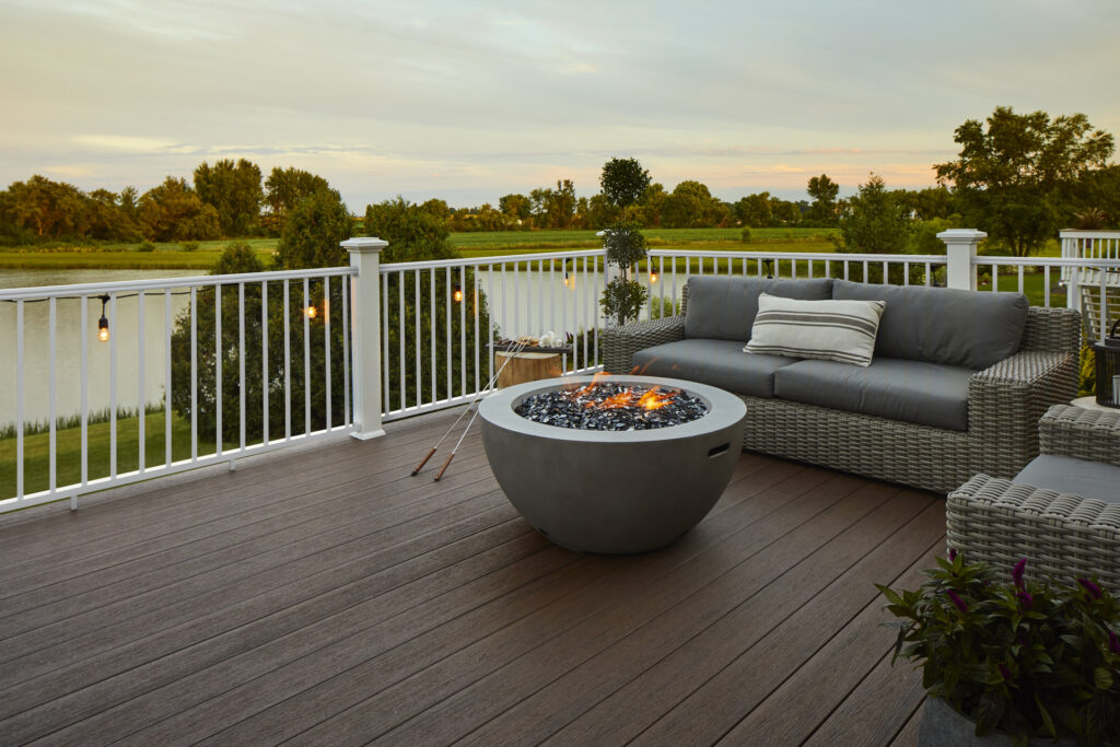 TimberTech Reserve Dark Roast composite deck with a cozy fire pit, overlooking a scenic lake view.
