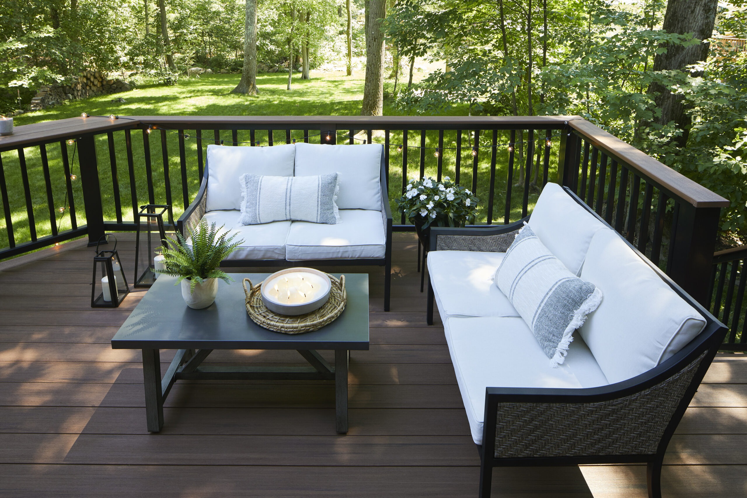 A beautifully designed backyard deck with TimberTech Vintage Mahogany decking, featuring a cozy seating area with woven furniture, creating the perfect outdoor retreat.