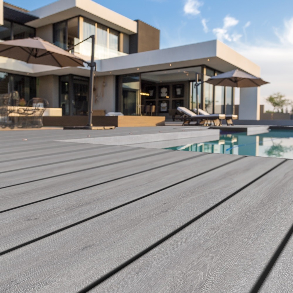 Eva-Last Pioneer Weathered Ash deck boards surrounding a luxury pool area, blending contemporary style with natural woodgrain texture.
