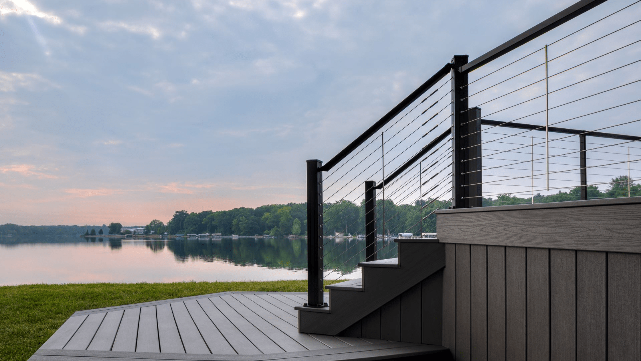 Cable deck railing installed along stairs, measured to meet deck railing height code between 34 and 38 inches.