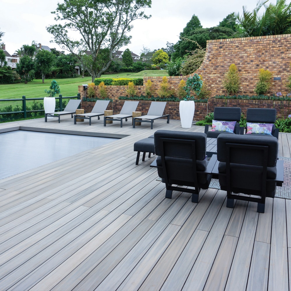 Outdoor space showcasing Eva-Last Infinity IS Caribbean Coral decking in a wide plank layout with lounge chairs and seating.