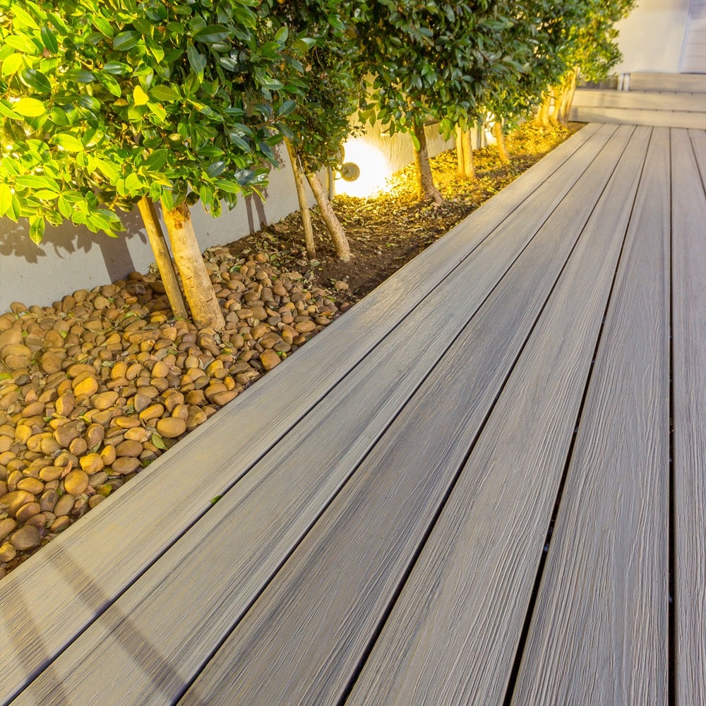 Caribbean Coral decking from the Eva-Last Infinity IS collection shown in a wide board configuration along a landscaped walkway.