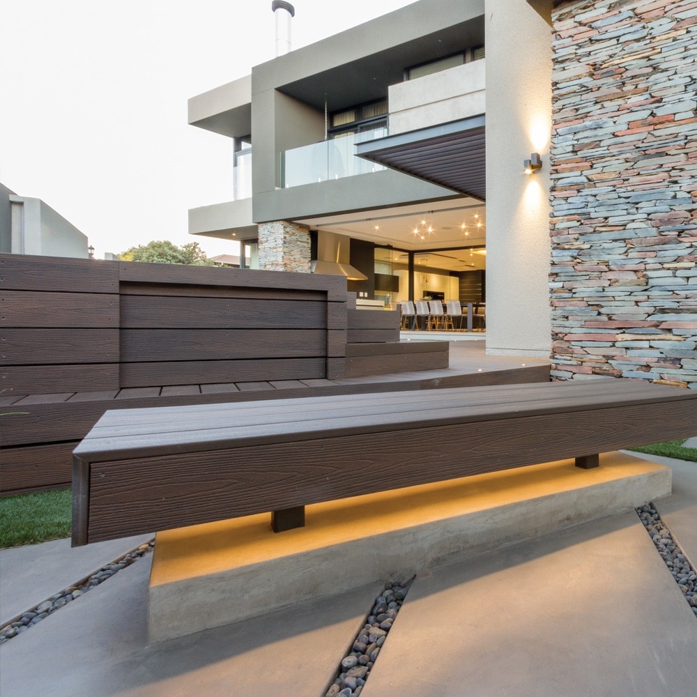 Tiger Cove Infinity IS deck boards used in modern outdoor bench seating, displaying the board’s dimensional grain and dark, natural wood look.