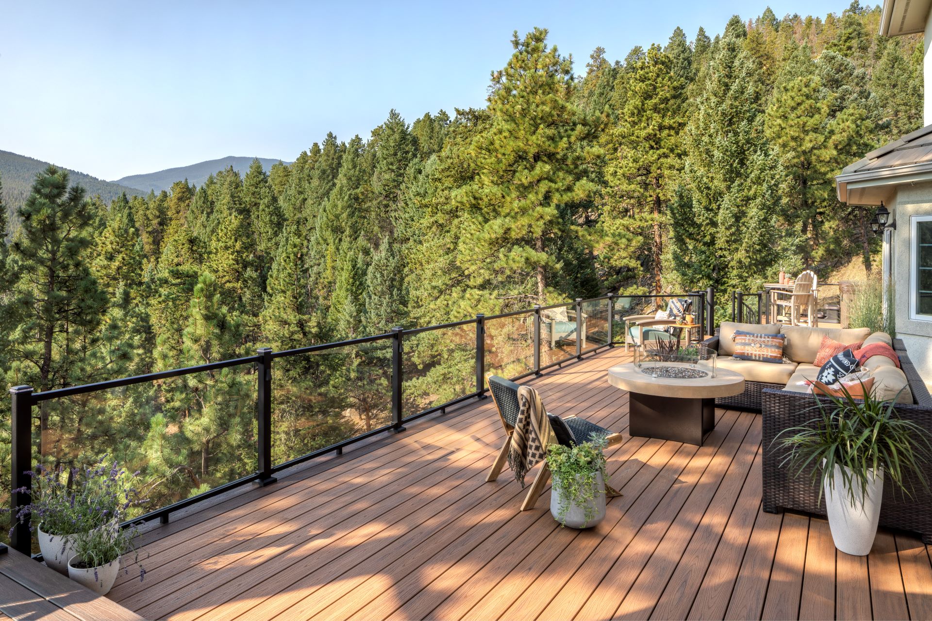 Glass panel deck railing system on a high-elevation residential deck, designed to meet minimum deck rail height for safety.
