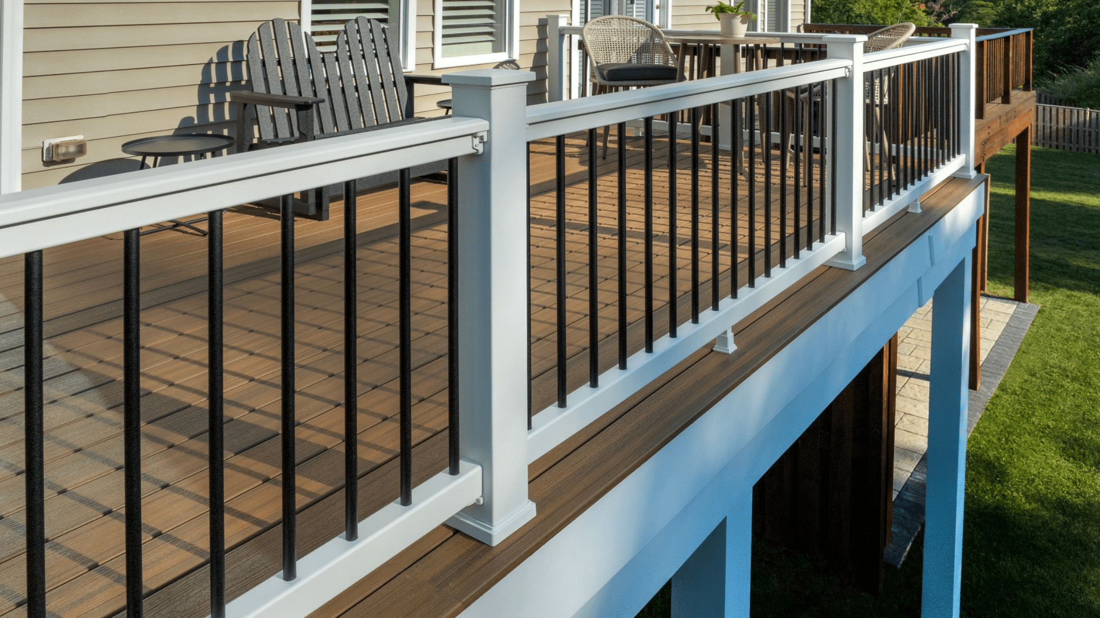 Black vertical spindle deck railing on an elevated backyard deck, built to match local building codes for deck railing height.