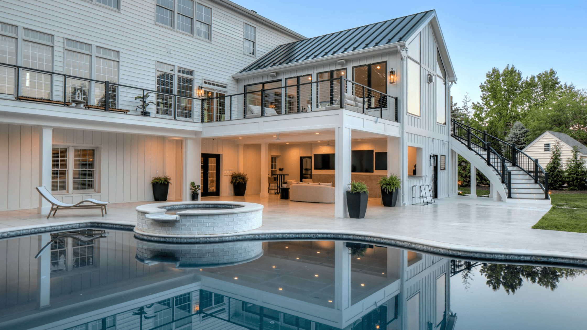 Backyard deck with cable railing around pool area, showing a completed railing system built with deck railing height in mind.