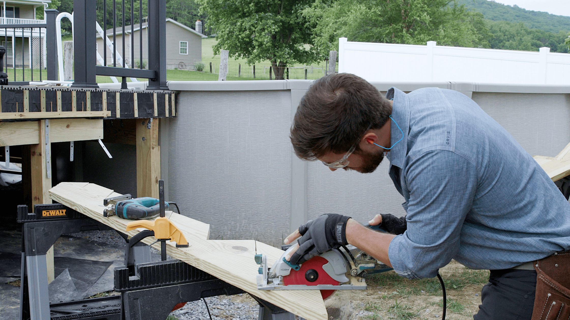 Contractor cutting lumber with a circular saw during a deck remodel project, showing the cost to replace deck boards.