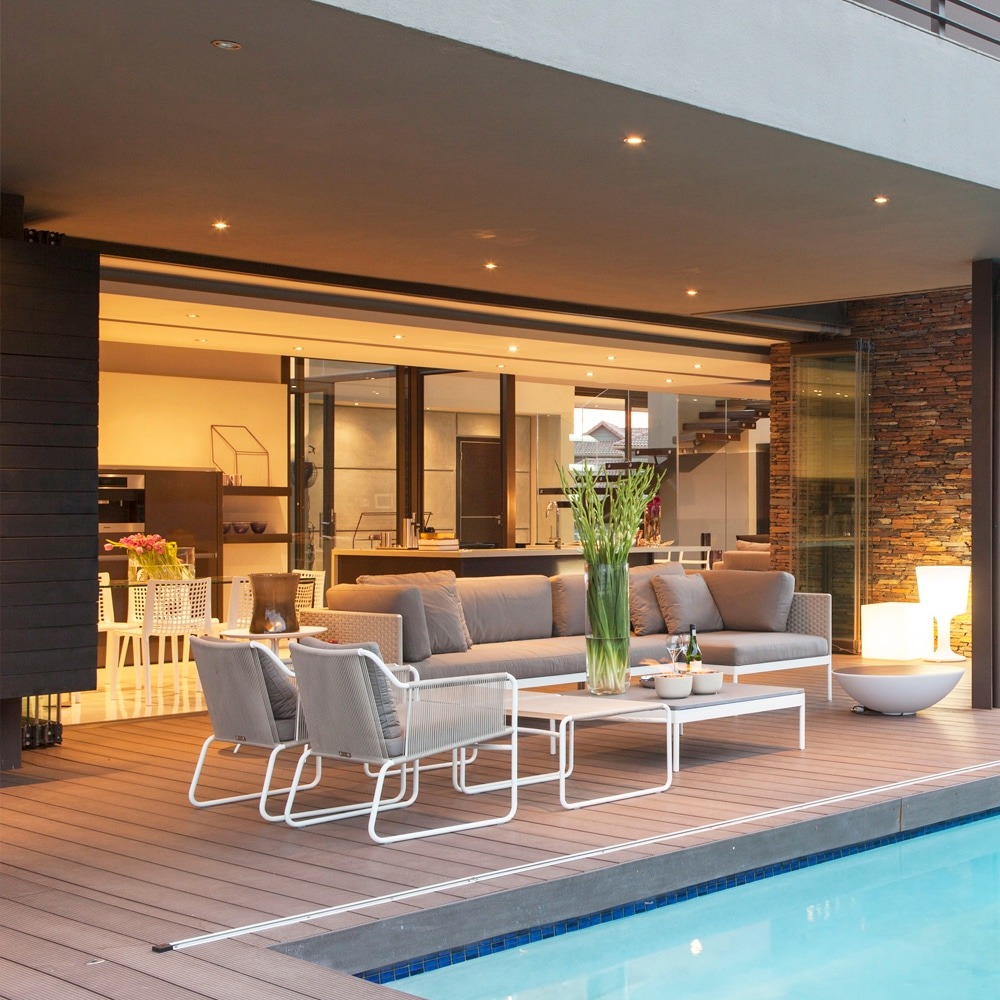 Stylish outdoor seating area using Eva-Tech IS Wyde Rusteak boards with modern furnishings and ambient lighting.