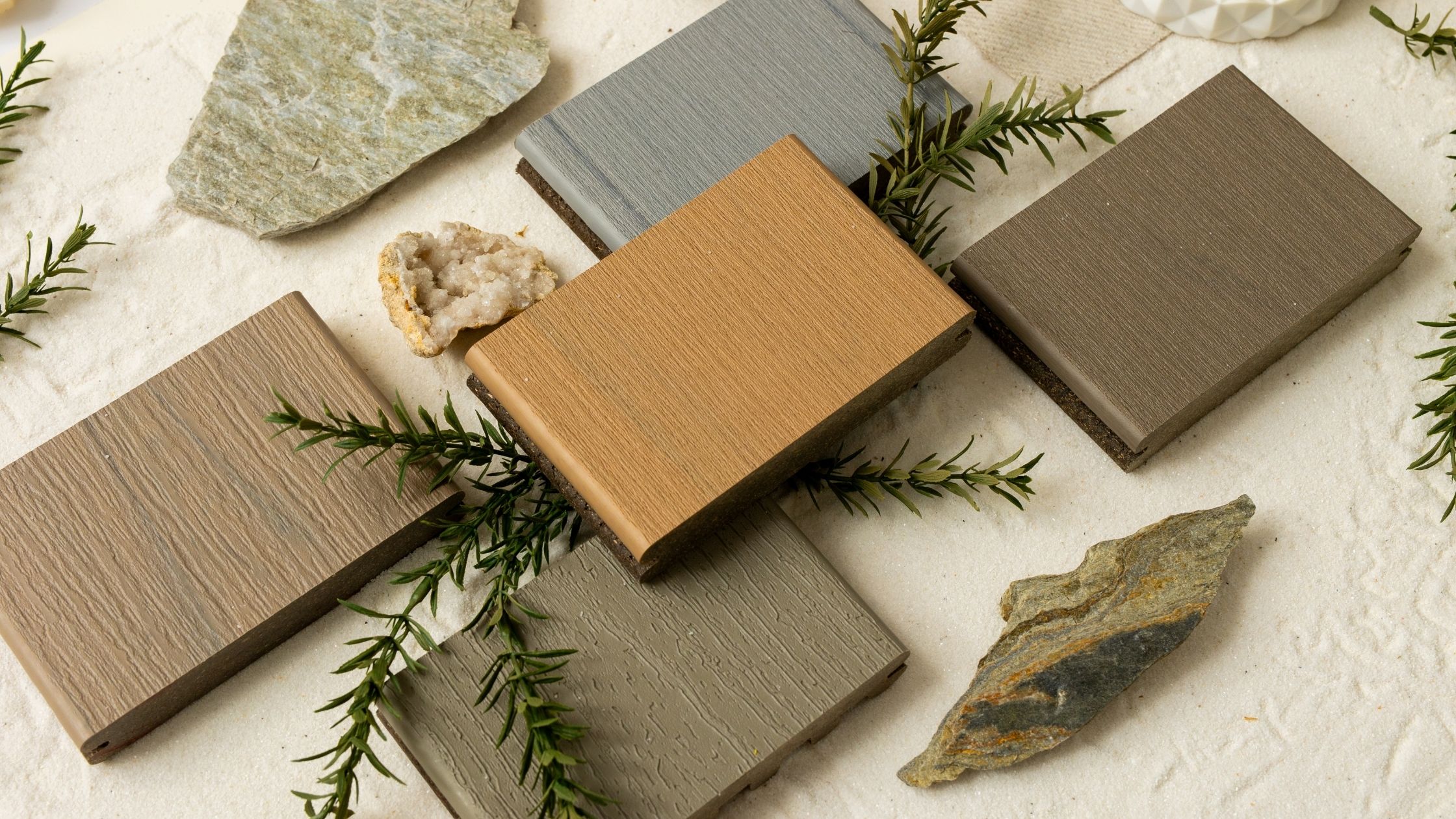 Assorted composite decking samples in natural tones, used to compare decking material types when planning standard deck sizes.