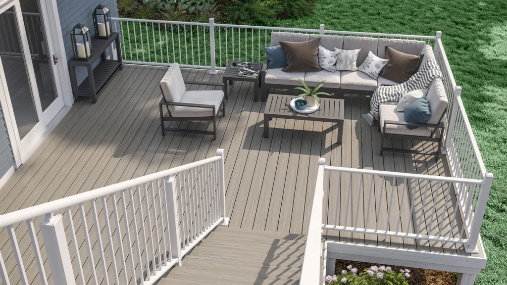 Backyard deck featuring Deckorators Venture Saltwater boards, styled with white railings and rattan furniture, creating a calm and inviting space with a naturally weathered look.