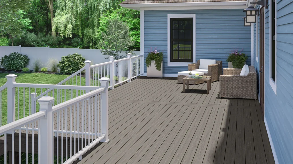 A modern outdoor seating area built with Deckorators Venture Saltwater decking, styled with white railings and neutral patio furniture to highlight the board’s elegant, sun-washed gray finish.