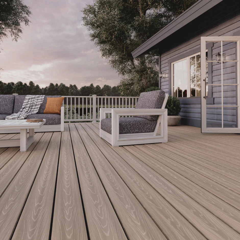 Spacious backyard deck built with ArmorGuard Aspen Gray decking, featuring modern white railings, neutral furniture, and surrounding greenery for a clean, contemporary outdoor space.