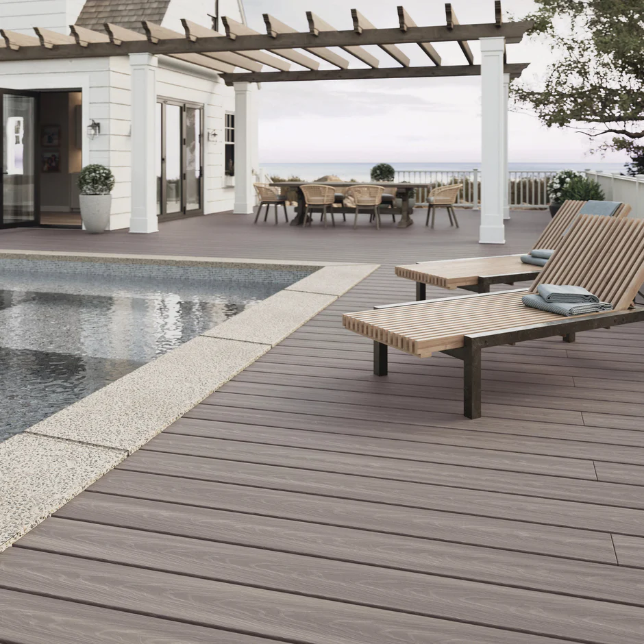 Outdoor patio with Fiberon ArmorGuard Coastal Gray decking, styled with dark wicker seating, accent pillows, and soft lighting for a cozy, relaxed atmosphere.