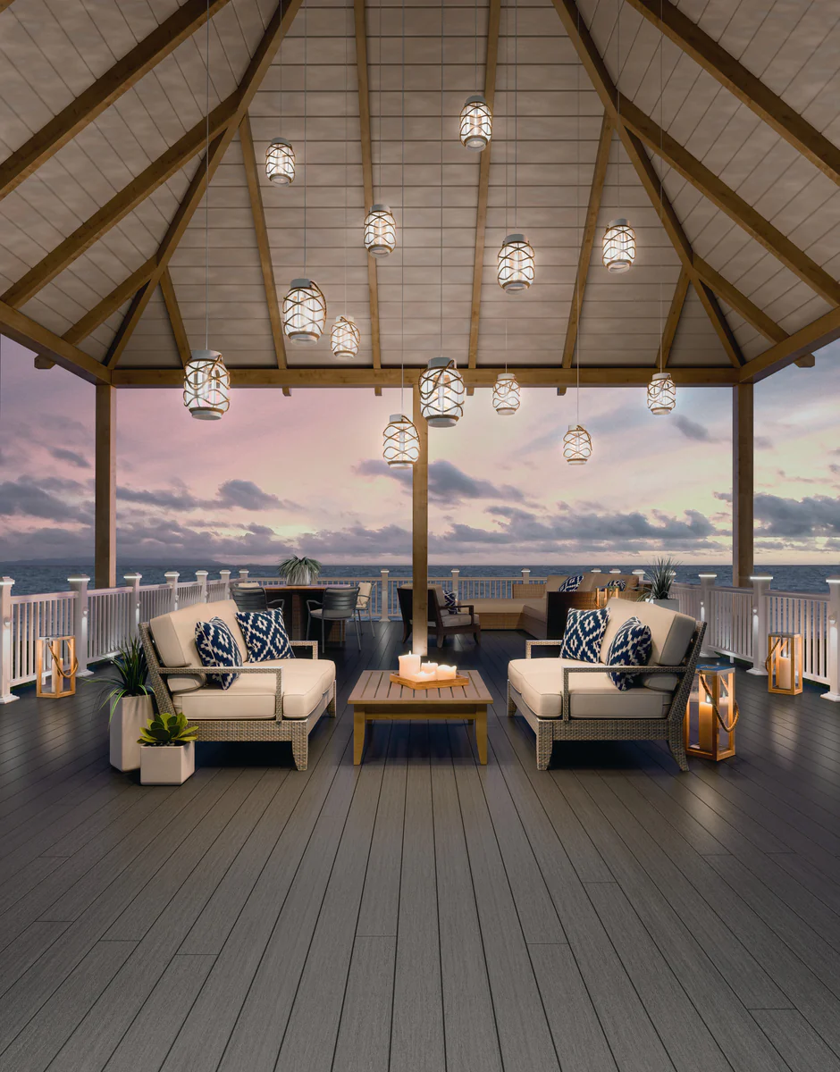 Medium grey composite decking styled under a covered pavilion with ocean views, white railings, and coastal-inspired seating.