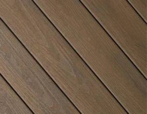 Close-up of Fiberon Concordia decking in Mountain Ash, a deep brown-gray tone with rustic cathedral grain for a natural, weathered wood look.
