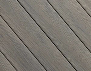 Detailed swatch of Concordia in Seaside Mist, a cool, soft gray with sweeping woodgrain patterns evoking coastal driftwood.