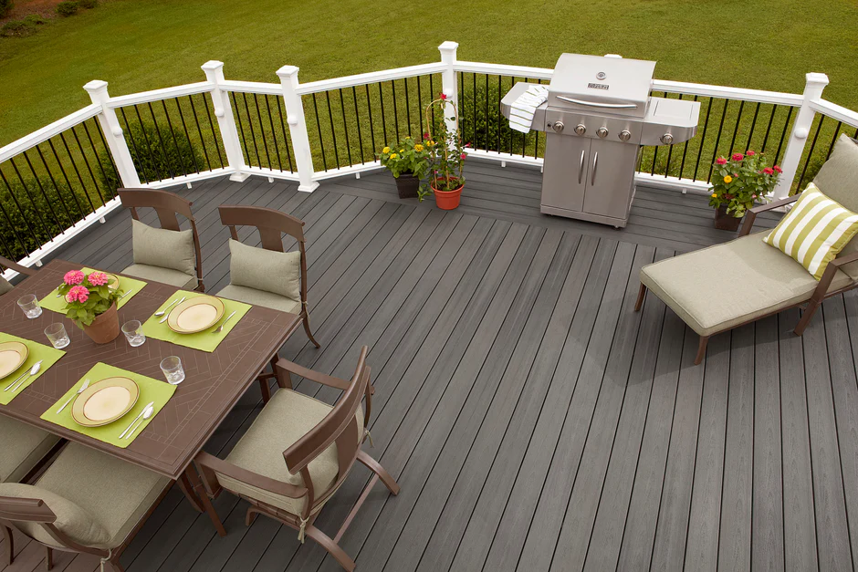 Second-story deck with Fiberon Sanctuary in Earl Grey, paired with black metal railings, wicker seating, and leafy backyard views for a clean, contemporary look.
