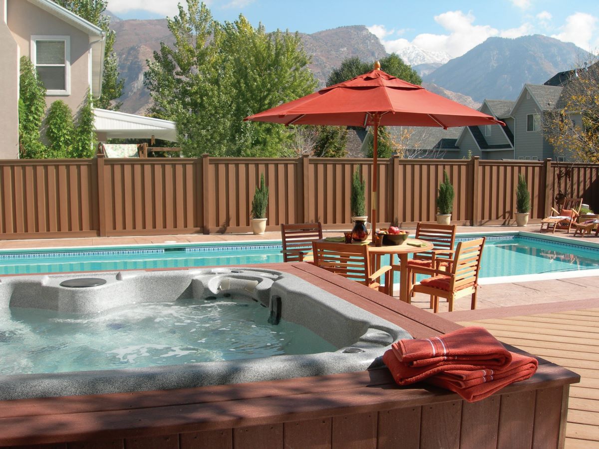 Larger deck over 400 square feet featuring a hot tub, pool, and outdoor dining area, built using standard deck board size for entertaining.