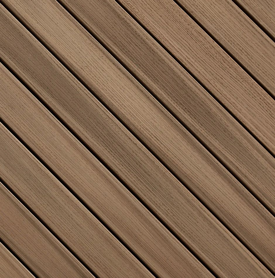 Close-up view of wood grain PVC deck boards arranged diagonally. These advanced PVC decking boards mimic natural wood while providing slip resistant performance and long-lasting aesthetic appeal.