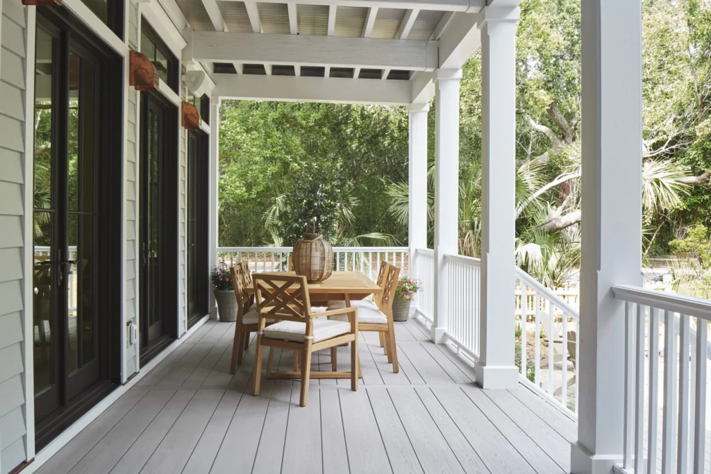 TimberTech Harvest Slate Gray Advanced PVC decking on a covered back porch, paired with warm wood furniture and white railing for a classic, coastal-inspired look.