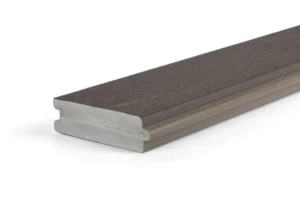 A close-up side profile of a TimberTech Porch Dark Hickory tongue-and-groove PVC decking board, showcasing its interlocking edges and smooth, low-gloss finish. The dark brown surface features subtle woodgrain texture over a dense gray PVC core.