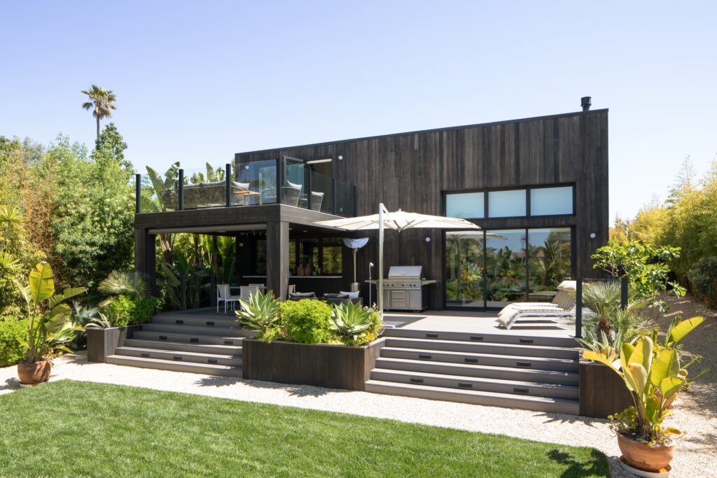Modern backyard with Trex Signature Whidbey composite decking, tropical landscaping, and built-in grill area.