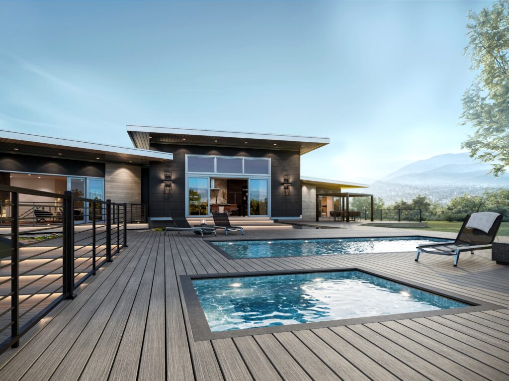Contemporary home with two pools and Trex Signature Whidbey composite decking, set against scenic hillside backdrop.