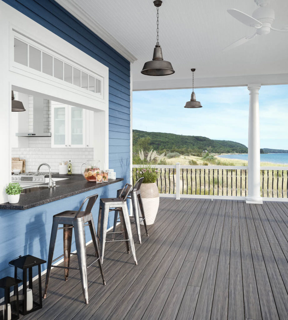 Deckorators Tidal Gray deck boards installed on a beachfront porch with bar seating and white railing, emphasizing the board’s weathered gray finish and relaxed, breezy vibe.