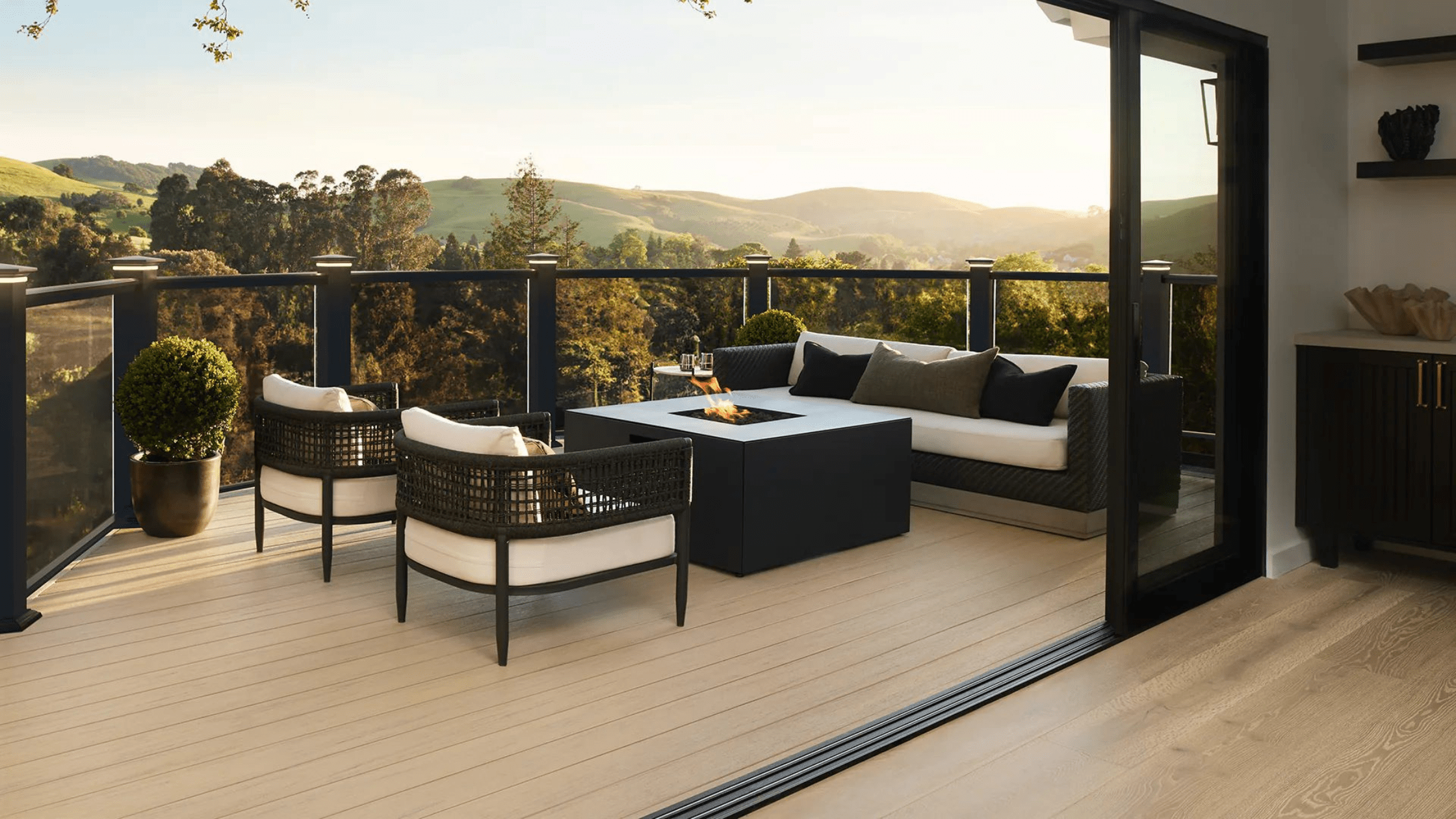 A clean TimberTech deck with outdoor furniture overlooking scenic hills, illustrating the beauty of a well-maintained composite deck after regular cleaning.