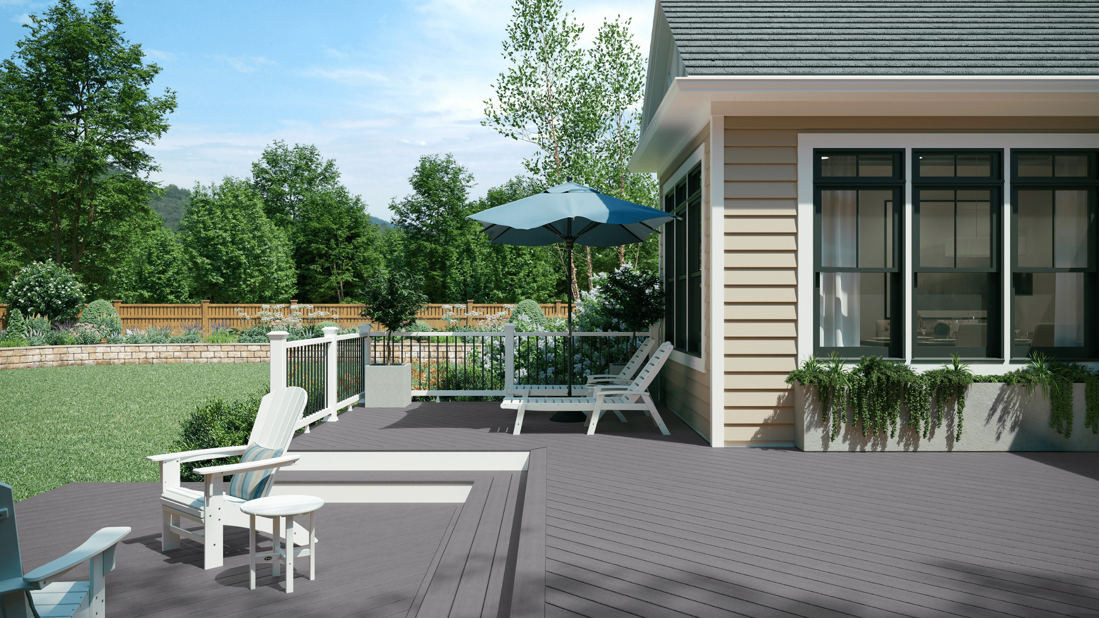 An outdoor deck finished in Trex Enhance Pebble Beach, a light gray tone that creates a calm, coastal look. The deck is styled with white railings, outdoor seating, and lush greenery, emphasizing the cool, timeless style of the Trex Enhance colors lineup.