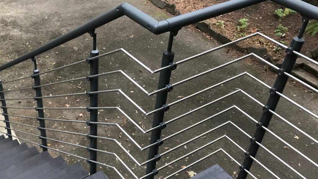 Stainless steel horizontal stair railing with artistic angled modern deck design.