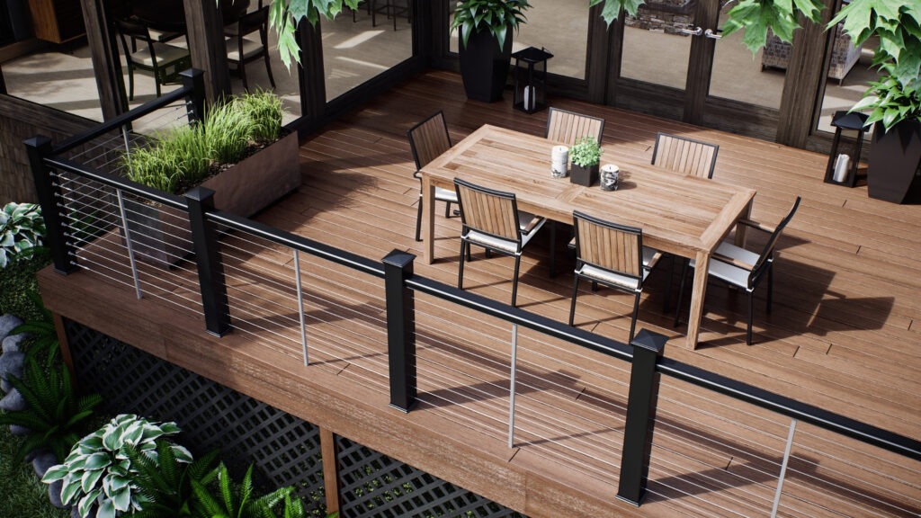 Brown composite deck with horizontal stainless cable railing by lake, contemporary cable railing ideas for deck spaces with natural wood tones.