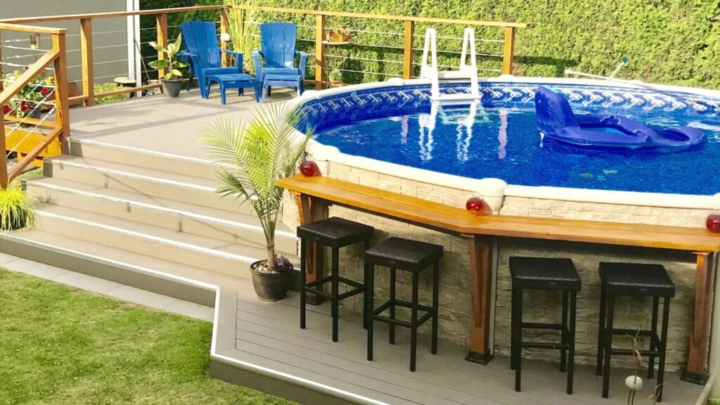 Composite pool deck with cable railings, bar counter, and outdoor lounge setup.