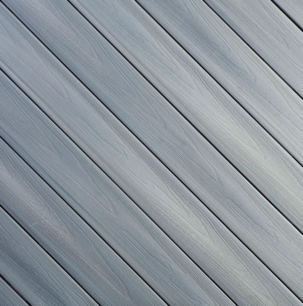 Close-up of Fiberon Concordia decking in Castle Gray, featuring a medium gray tone with light grain variation. The elegant, neutral color pairs beautifully with both traditional and modern exteriors.