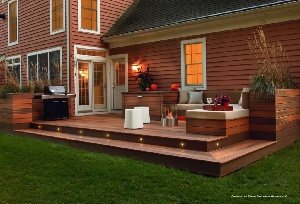 Evening view of a Fiberon Concordia Horizon Ipe deck with integrated lighting, a grill, and cozy outdoor seating, emphasizing the board’s rich, exotic brown color and elegant grain pattern.