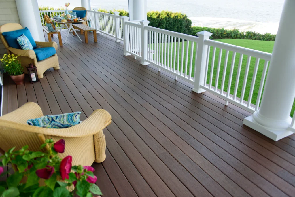 Overhead view of a Fiberon Concordia Symmetry Warm Sienna deck arranged in a herringbone pattern with cozy accessories - coffee mugs, a soft blanket, and a succulent - highlighting the board’s warm, golden-brown finish.