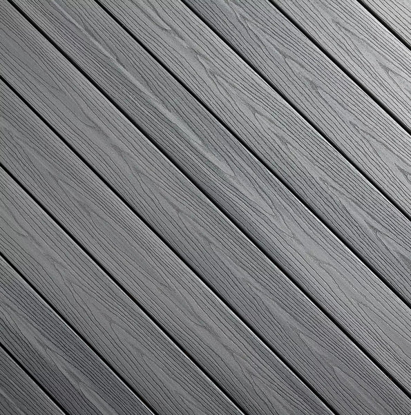 This swatch shows Fiberon Good Life Beach House, a cool medium gray decking color with natural-looking woodgrain texture running diagonally across each board. Subtle charcoal streaking adds dimension, giving it the appearance of gently weathered coastal wood. The tone feels relaxed, clean, and perfect for modern outdoor spaces.