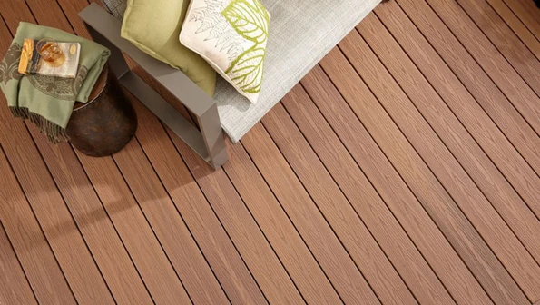 A top-down view of a deck built with Fiberon Good Life Bungalow decking, featuring warm brown boards with gentle, natural woodgrain patterns. Outdoor seating and decor rest on the surface, showcasing how Bungalow creates an inviting, earthy atmosphere in outdoor spaces. The multi-tonal color variation highlights the board’s realistic wood look and low-maintenance composite construction.
