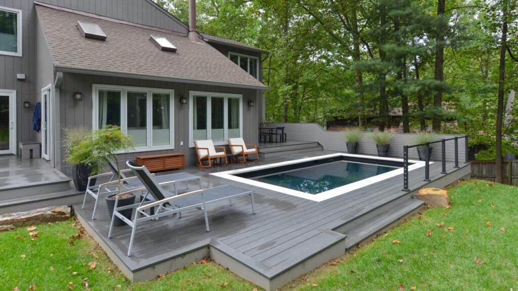 Rectangular pool with gray composite decking and modern outdoor seating area.