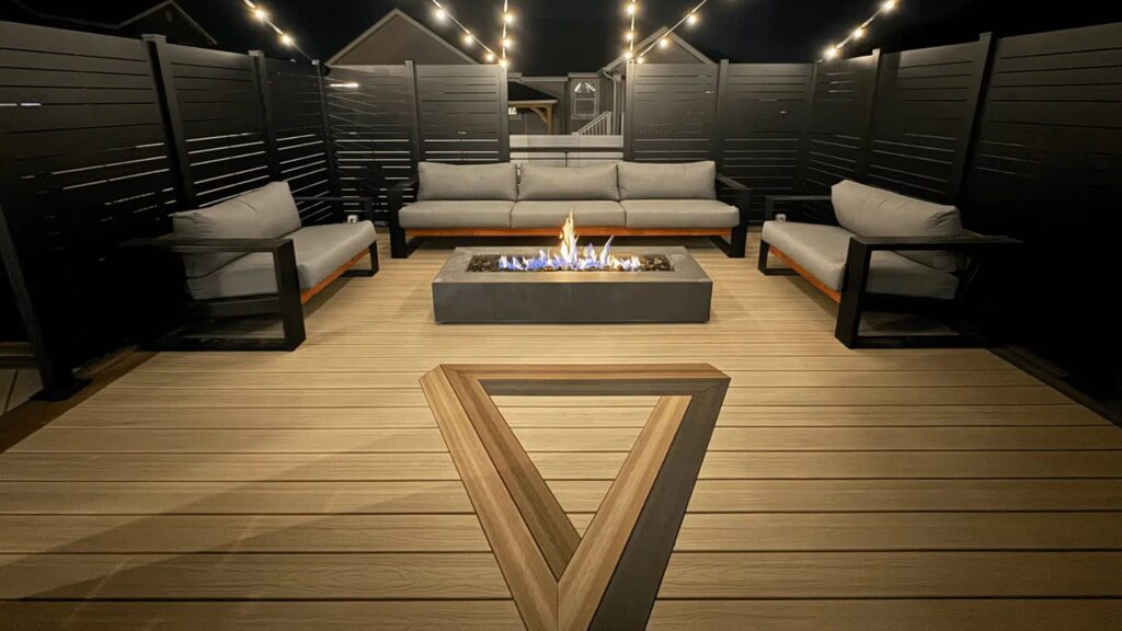 Clean Envision composite decking at night with modern outdoor seating and fire feature.