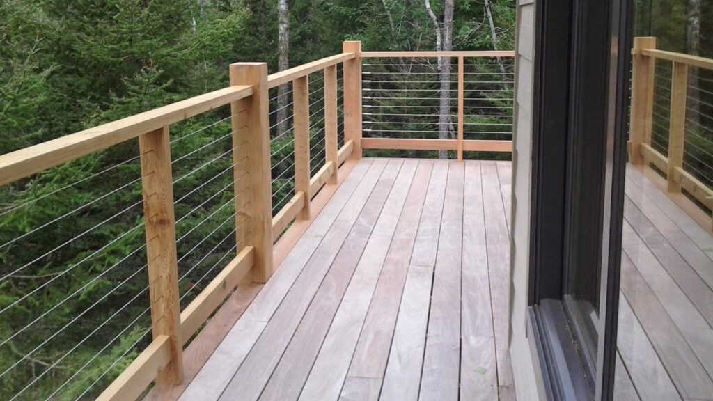 Ipe wood deck with stainless cable railing overlooking garden, premium example of cable deck railing ideas combining hardwood beauty and modern design.