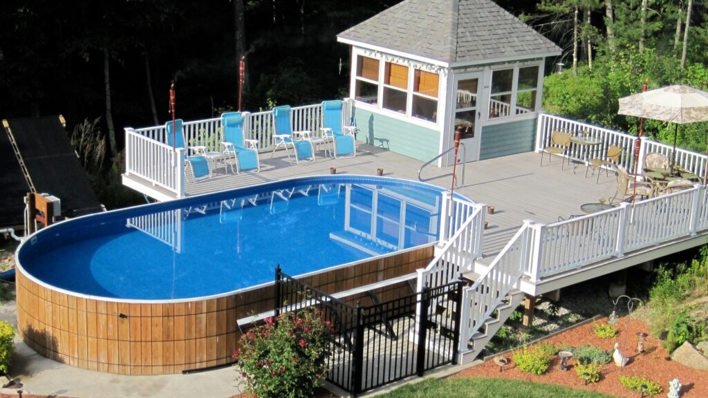 Large elevated above ground pool deck with white railings and lounge seating.