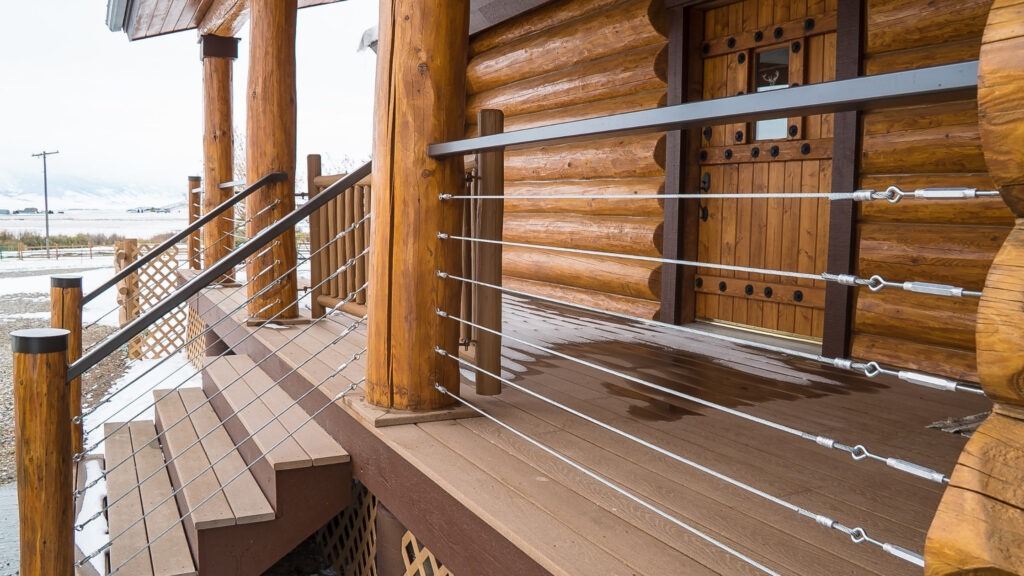 Log cabin stairs with round timber posts and stainless cable railing.