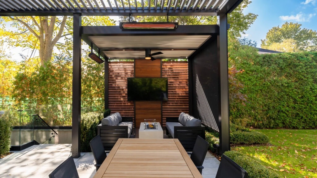 Luxury black pergola with wood privacy wall outdoor tv and dining furniture in backyard.