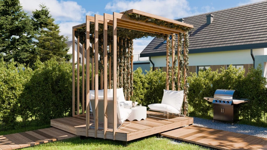 Minimal wood pergola with hanging greenery, two lounge chairs, and outdoor grill on small deck.