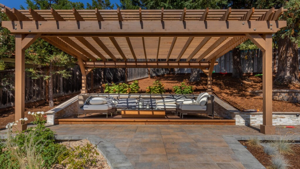 Modern cedar pergola with built-in seating area and open backyard view.
