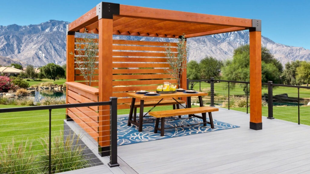 Cedar pergola on deck with mountain view and outdoor dining setup.