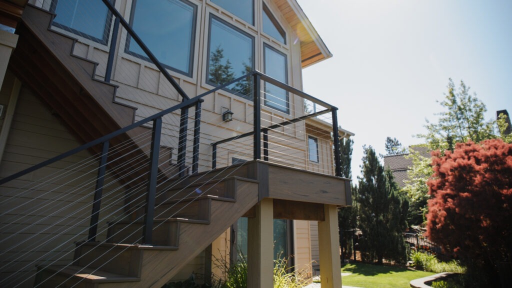 Black post stair with stainless cable deck railing on composite steps.