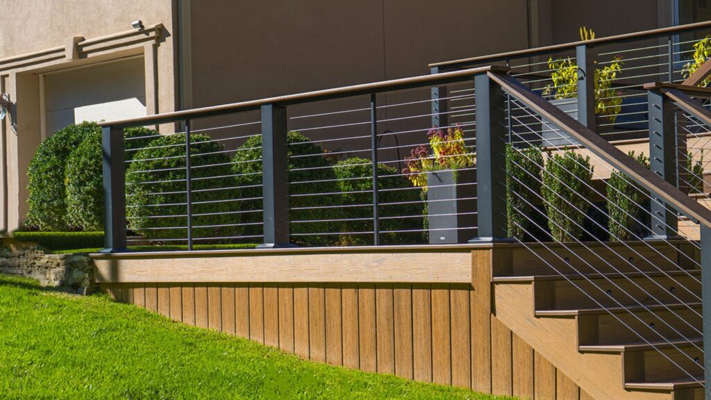 Modern horizontal cable stair railing with aluminum posts and wood accents on composite deck.